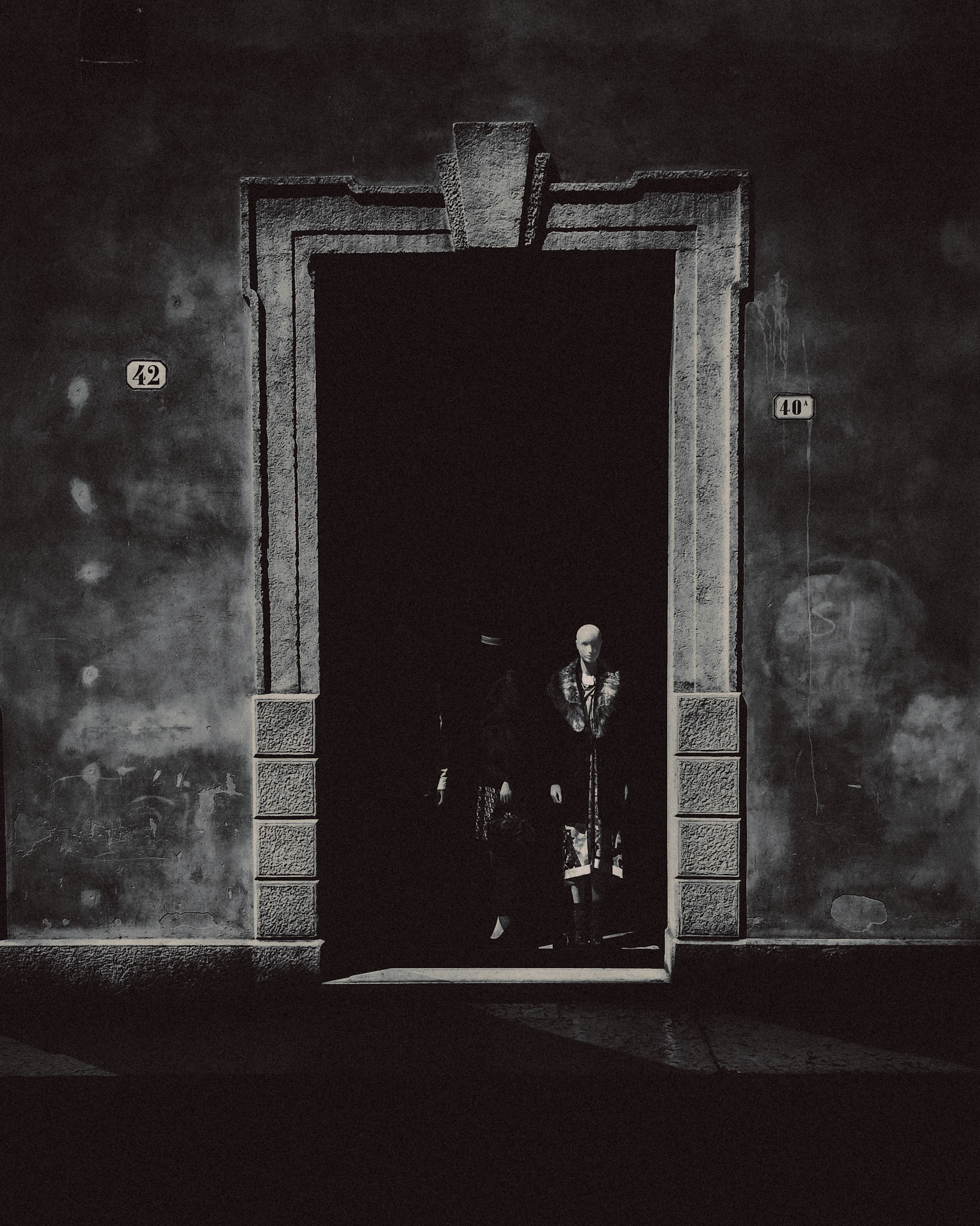 A manequin inside a shadowy boutique display, in black and white, Verona, Italy, September 2017, Huawei Mate 9 Pro.