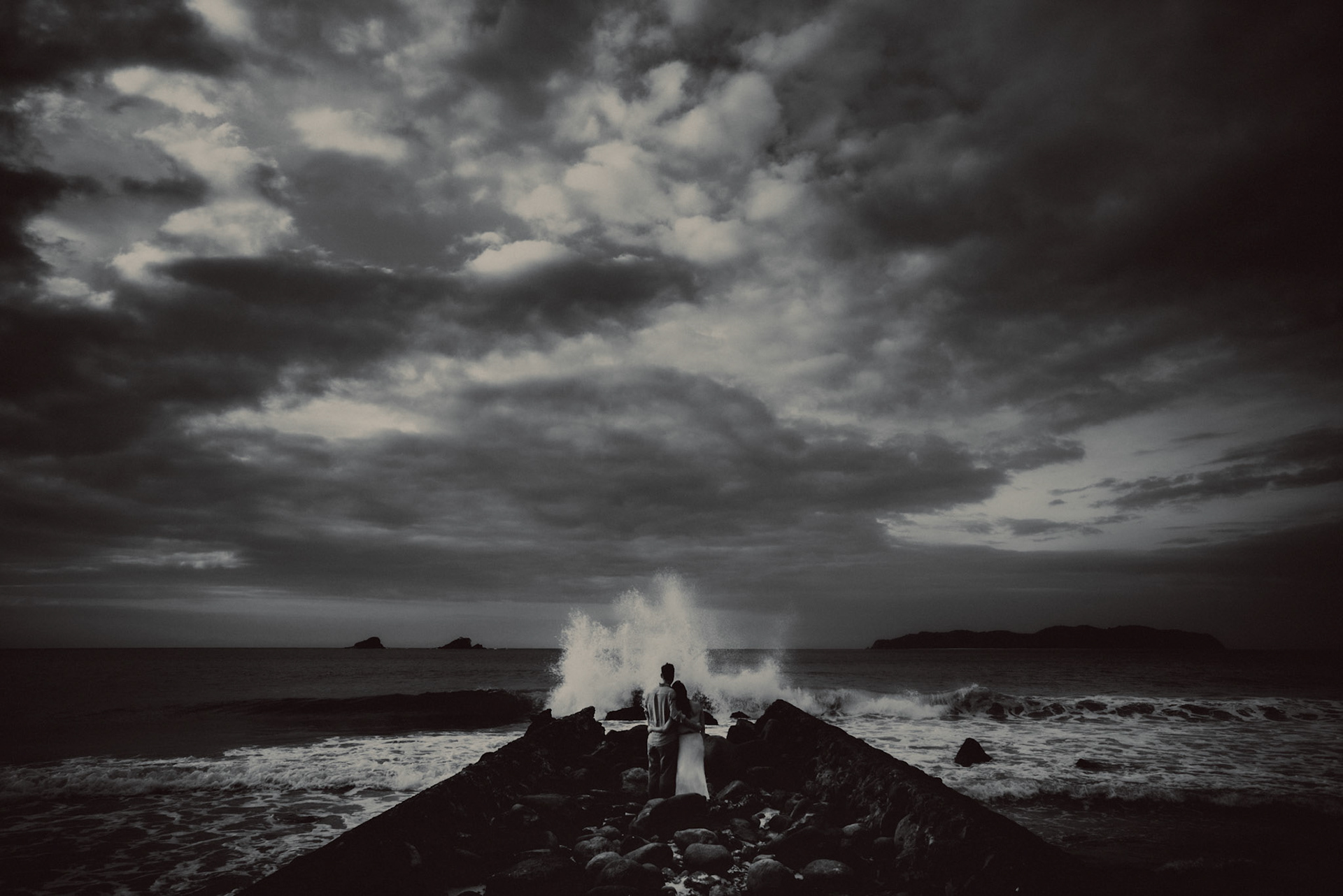 Moody black and white engagement portraits in front of crashing waves in Nacpan Beach, El Nido, Palawan, Philippines, Southeast Asia, January 2017, Leica M
