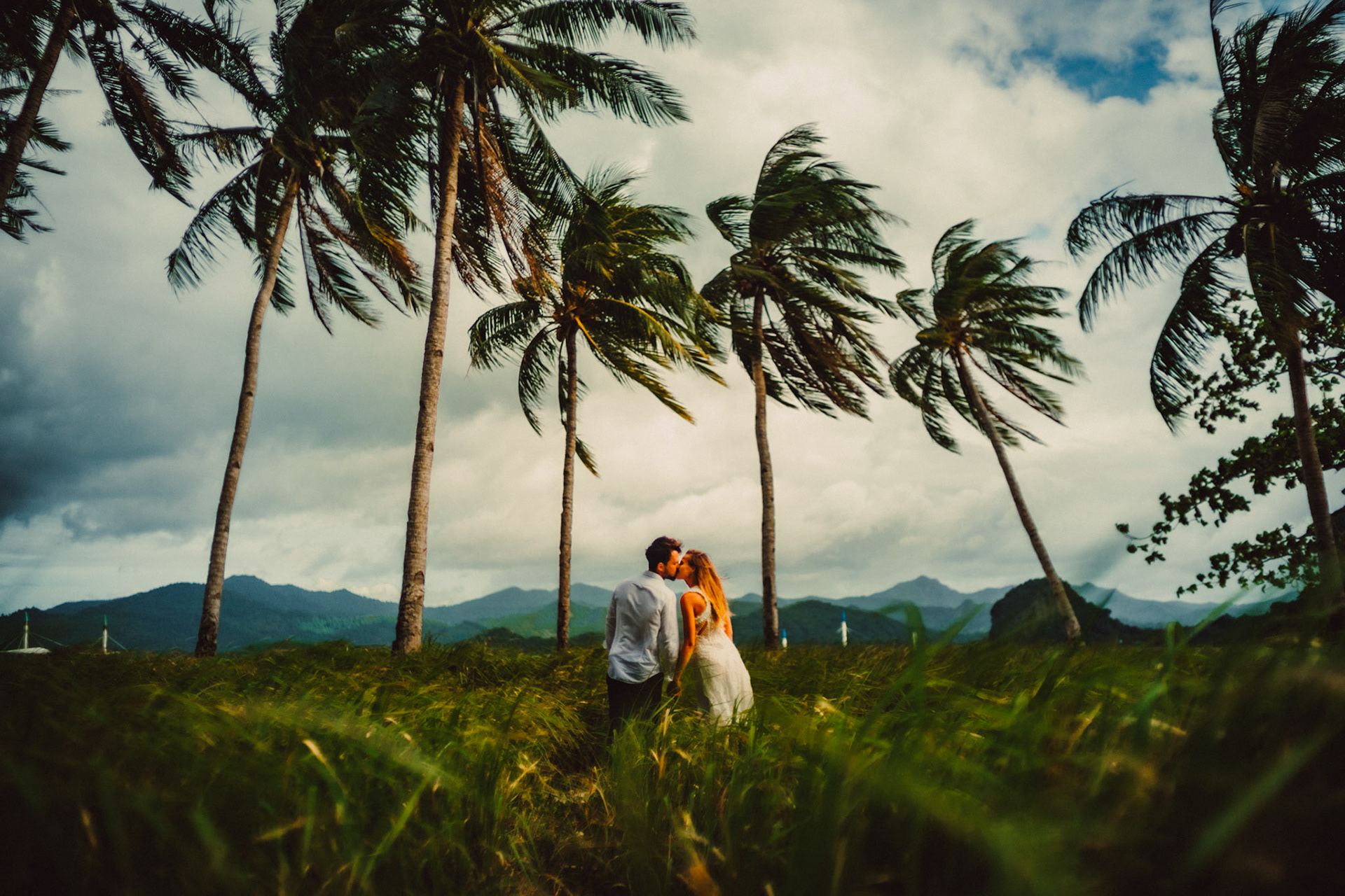 Travel couple portraits with a tropical vibe, palm trees and knee-high cogon grass, Pinagbuyutan Island, El Nido, Palawan, Philippines, Southeast Asia, December 2019, Sony A7III.