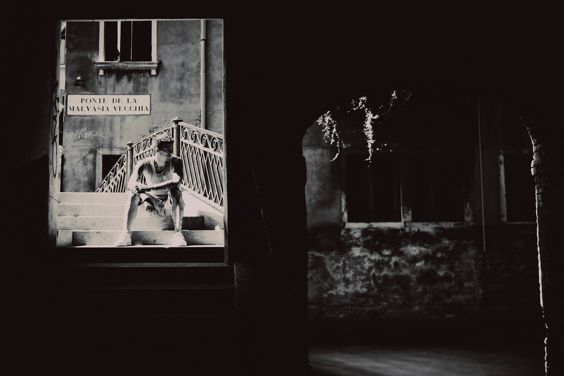 An aspiring actor sitting in Ponte de la Malvasia Vecchia, Venice, Italy, August 2017, Leica M.