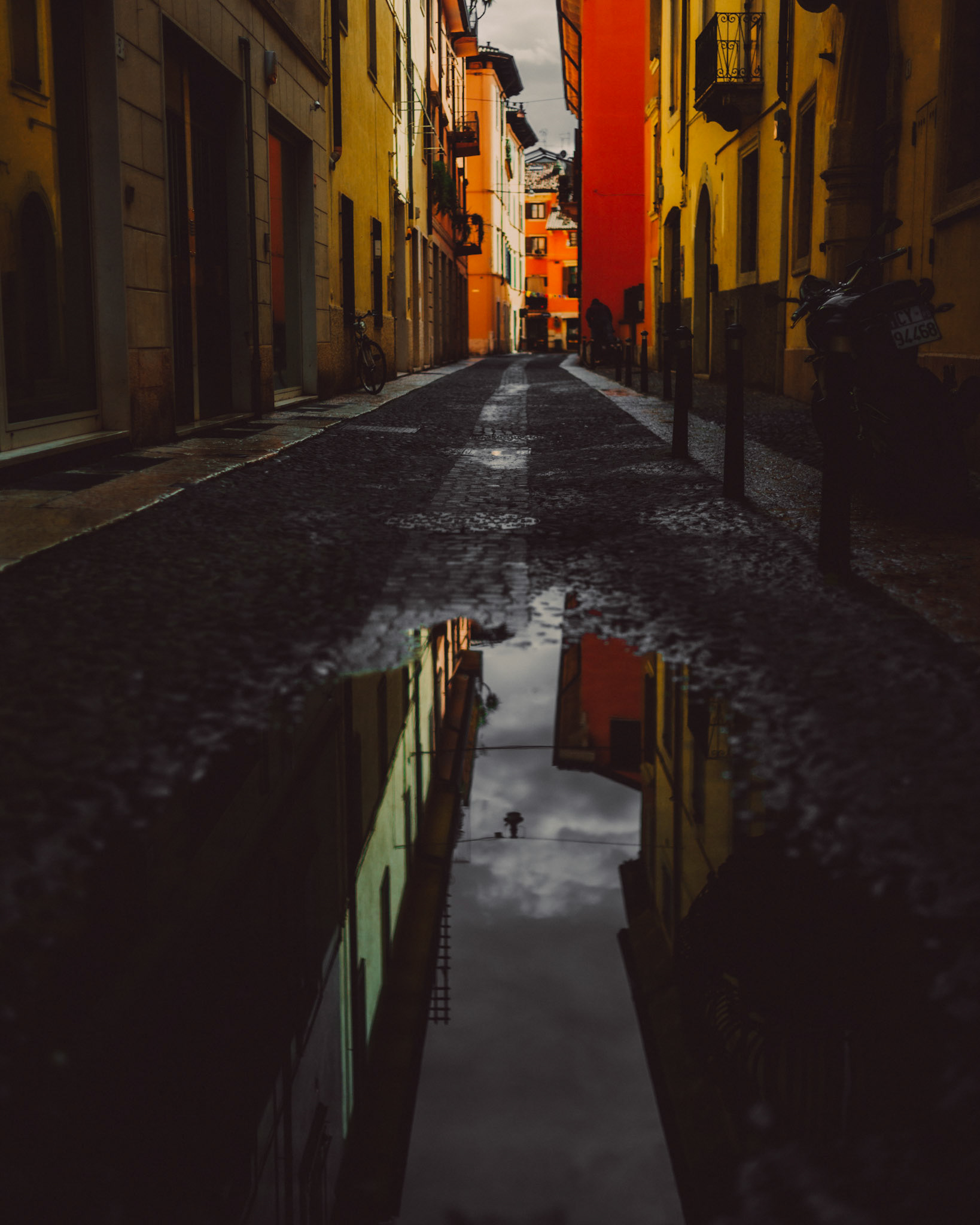 A puddle reflecting the sky and some brightly colored houses, Verona, Italy, September 2017, Huawei Mate 9 Pro.