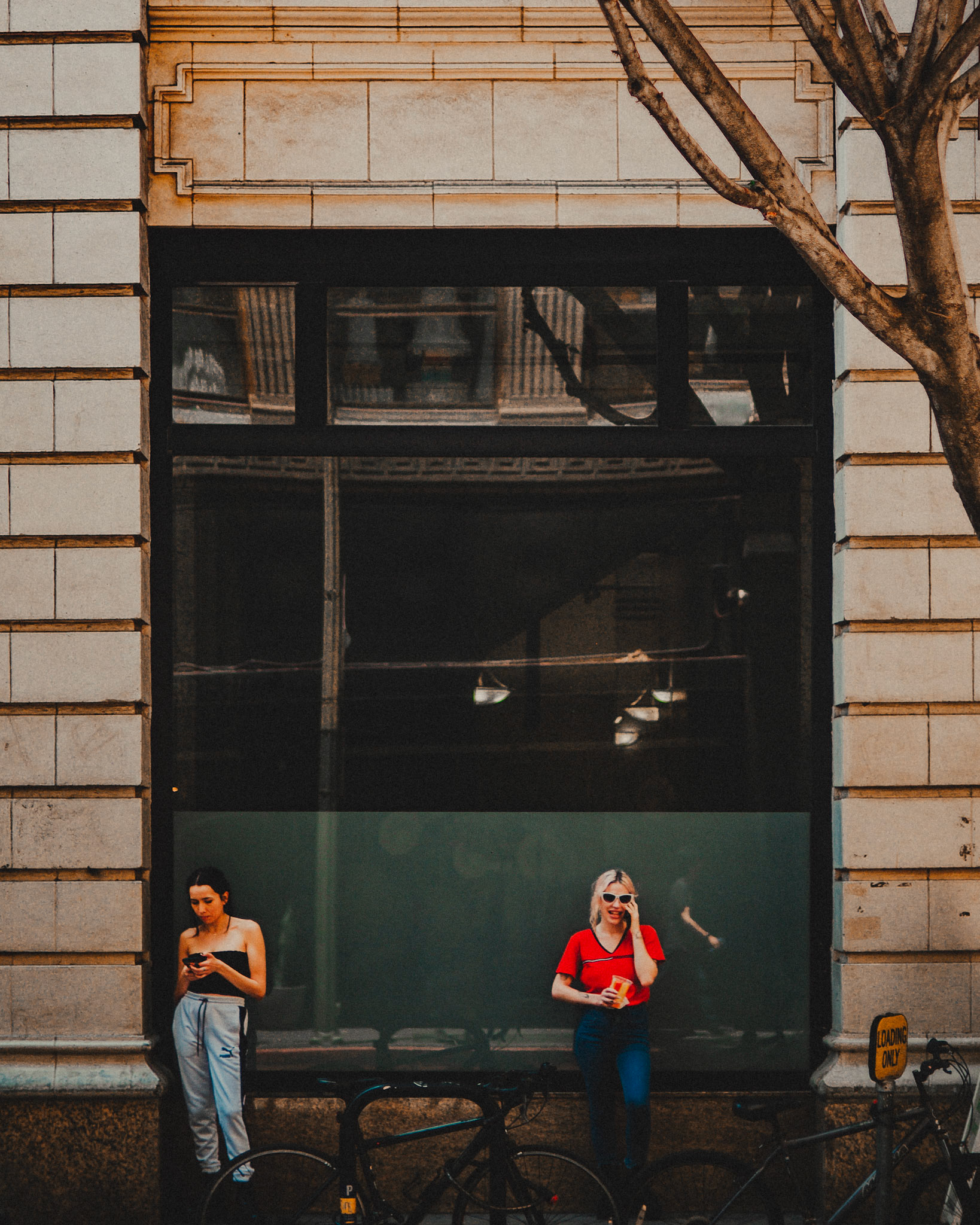 Women standing along W 9th St, Los Angeles, California, USA, July 2018, Leica M.