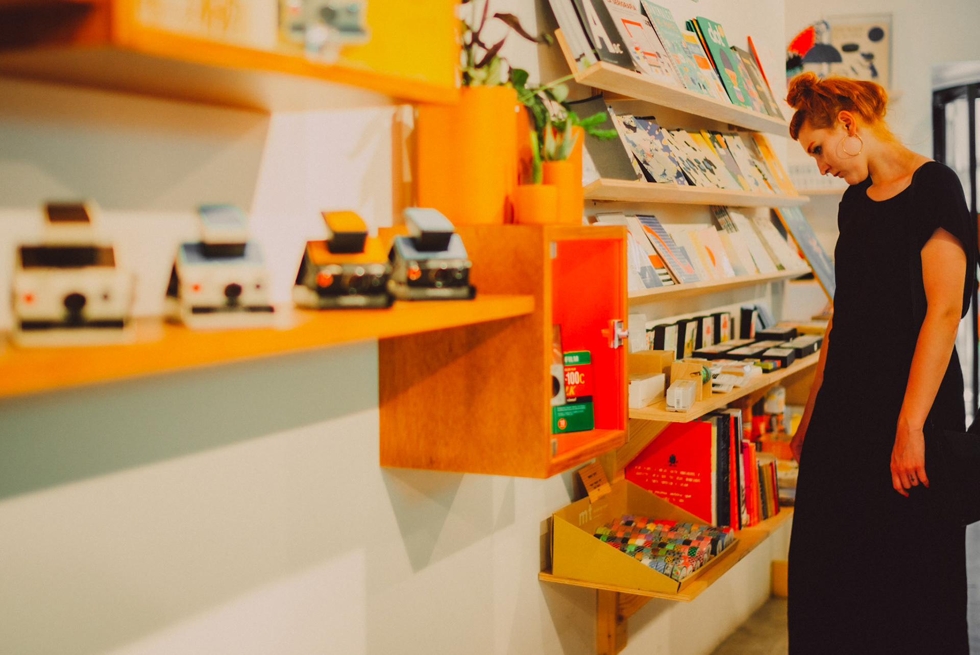 A woman browsing instant film cameras in Chandal, Barcelona, Spain, July 2016, Leica M.