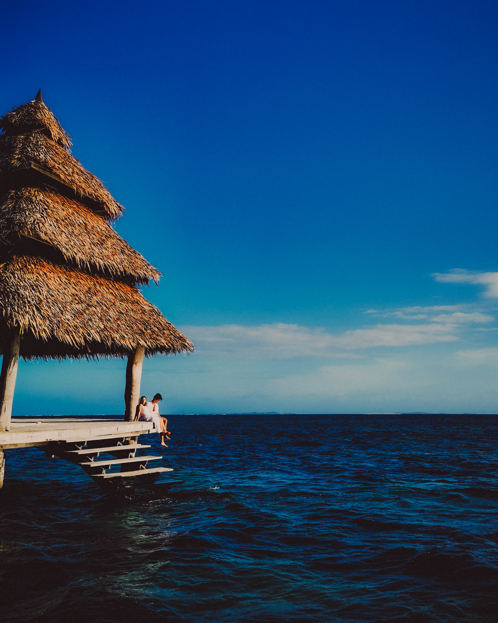 A couple sitting on a pagoda in the middle of the sea, Nay Palad Hideaway, Siargao Island, Philippines, February 2020, Huawei P30 Pro.