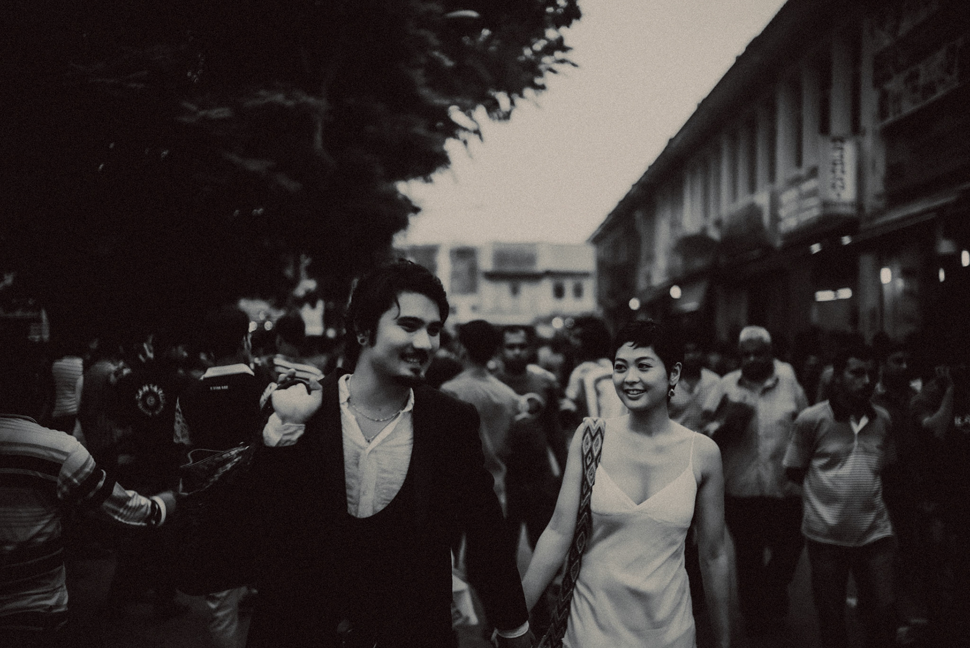 A candid, reportage-style engagement shoot in Little India on a Sunday afternoon feauring a Japanese couple, in black and white, Farrer Park, Singapore, October 2015, Sony A7S.