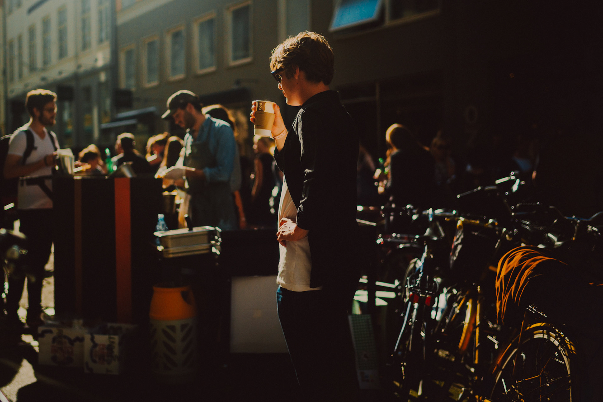 A Scandinavian man holding a cup of coffee at a summer street party, Copenhagen, Denmark, August 2015, Leica M.
