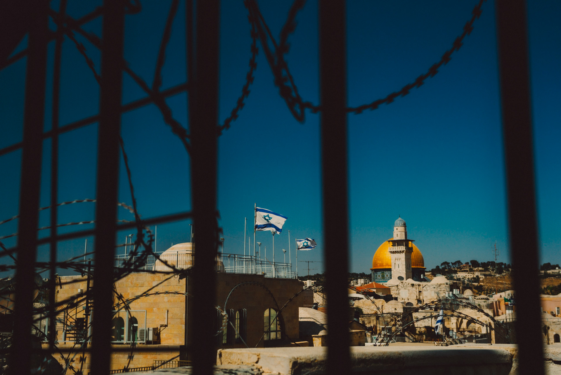 Dome of the Rock and the flag of Israel, shot through a barbed fence, Jerusalem, Israel, July 2015, Leica M.