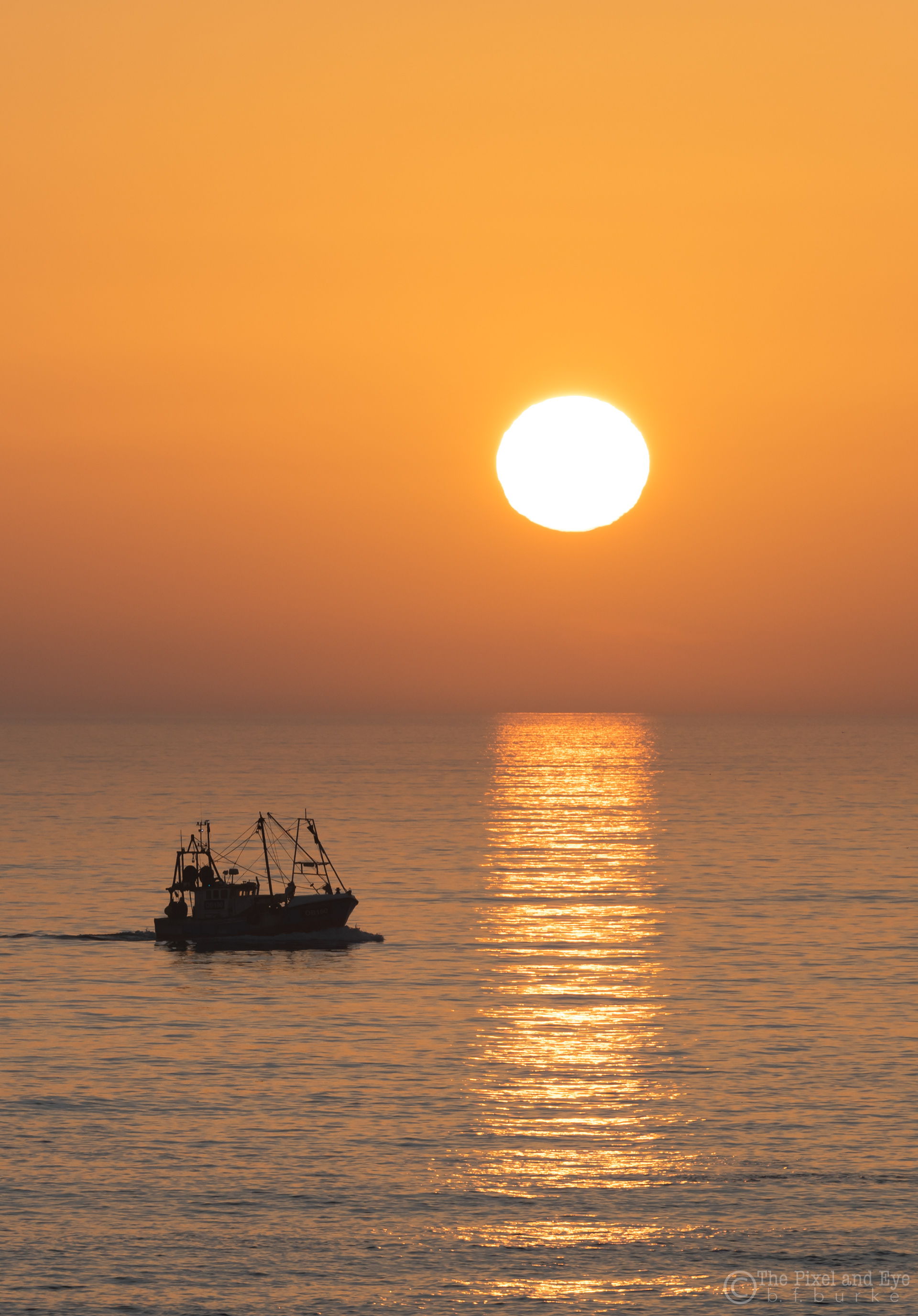 Phtotgraph of the sunrise and fishing boat