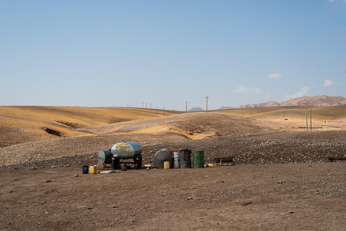 Les citernes à eau coupent l'horizon comme des murailles réconfortantes. Elles marquent la fin du campement, comme une barrière contre l'inconnu. Leur enveloppe brillante protège l'eau fraiche des rayons vifs du soleil. A peine remplies, elles seront rapidement vidées avec les besoins des familles et des troupeaux.
