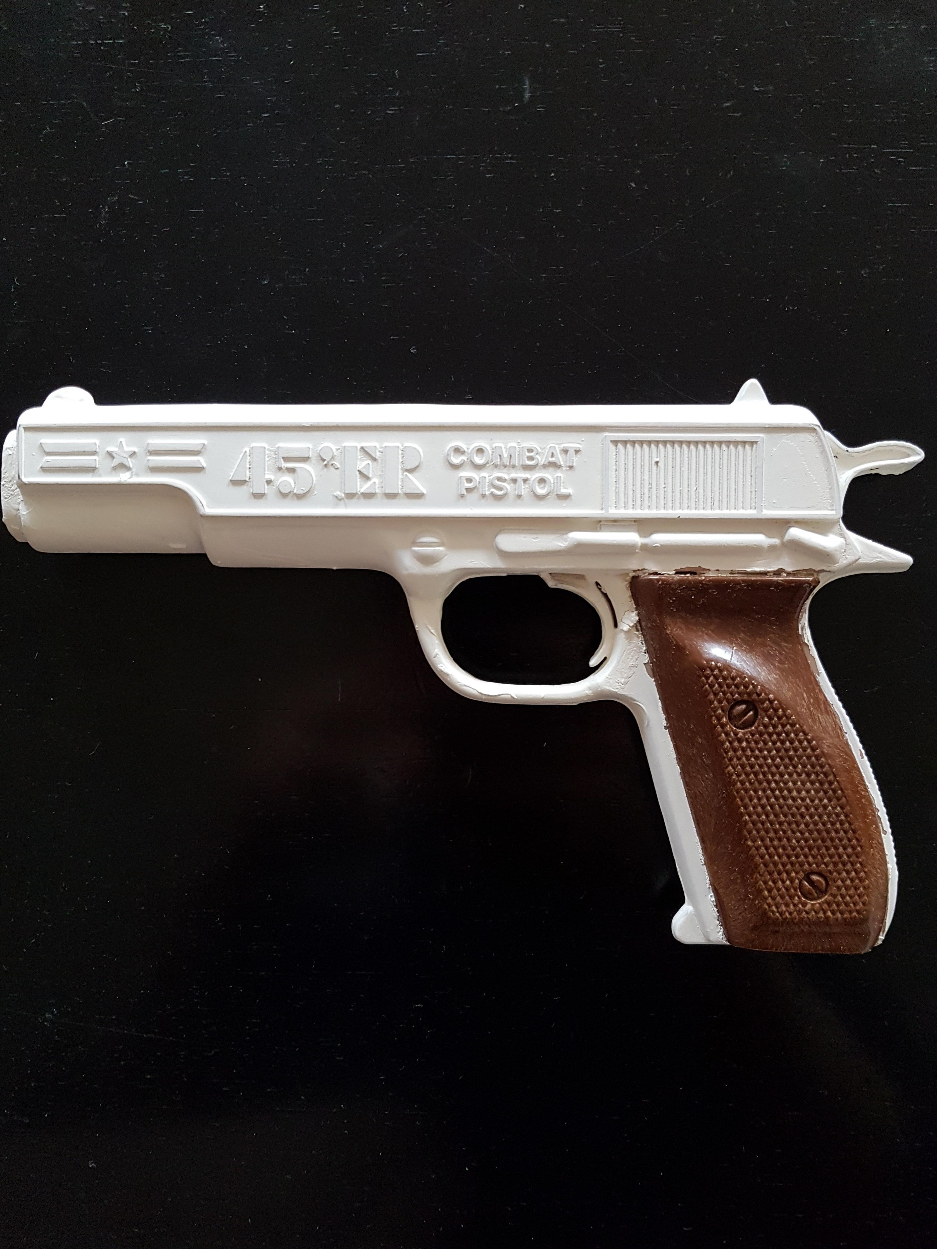 A realistic plastic toy handgun painted white.