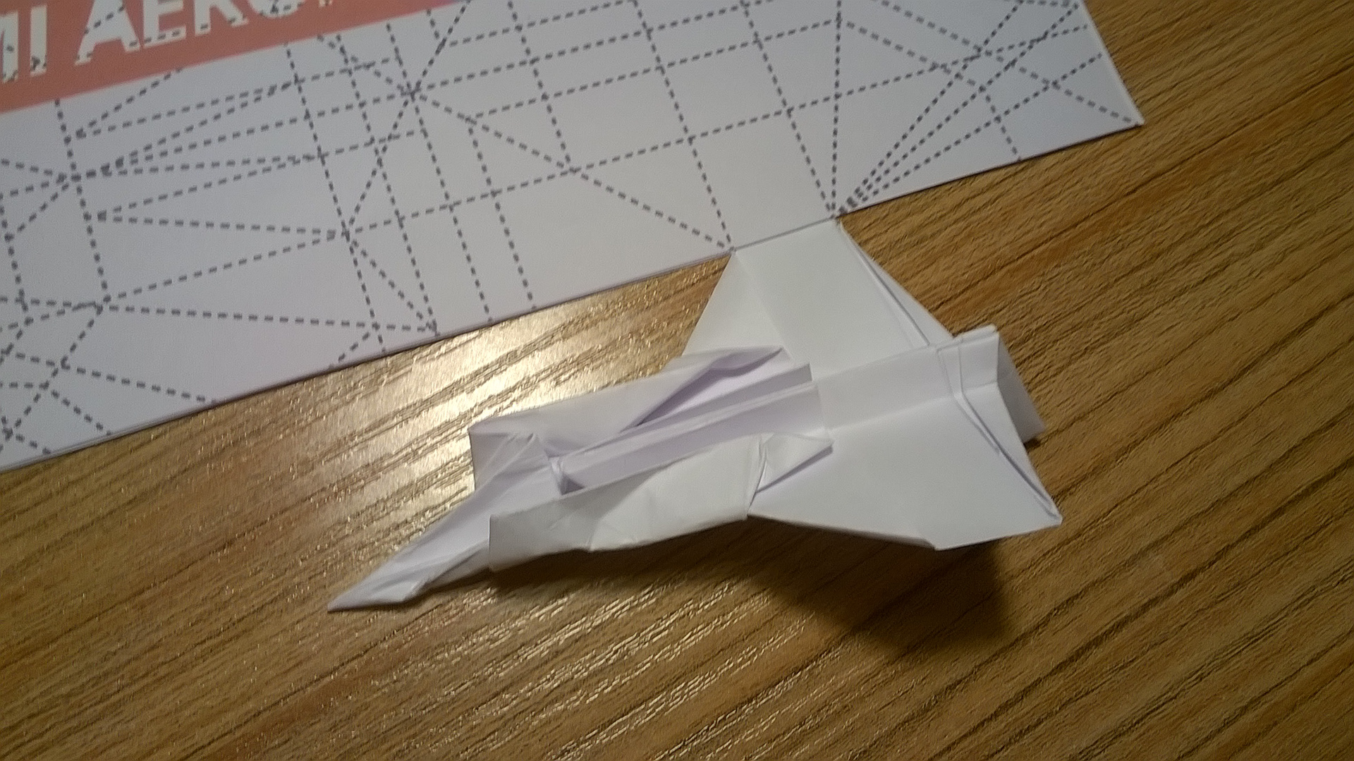 Closeup of an origami airplane attached to the poster.