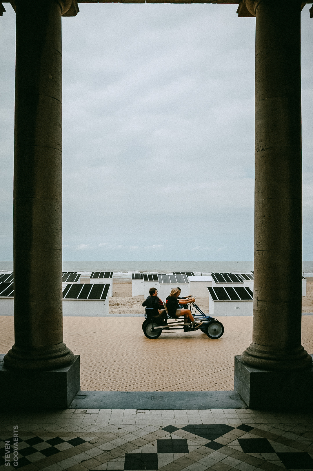 Welkom aan de Belgische Kust. Als je wil schuilen, staat er altijd wel ergens een bouwsel... of in dit geval een zuilengalerij. Je kan ook een cabine huren op het strand voor je zomerspullen. En een ritje met een cuisse-tax is haast obligaat.