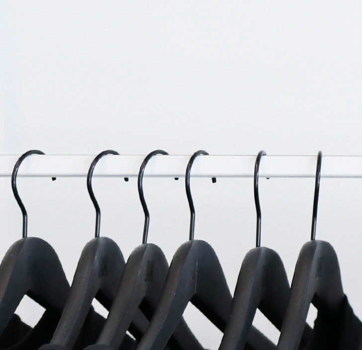 clean image of black clothes hangers on a white rail to illustrate consistency in product photography on Lindsey L Ahmet Professional Graphic Designer and photographers blog