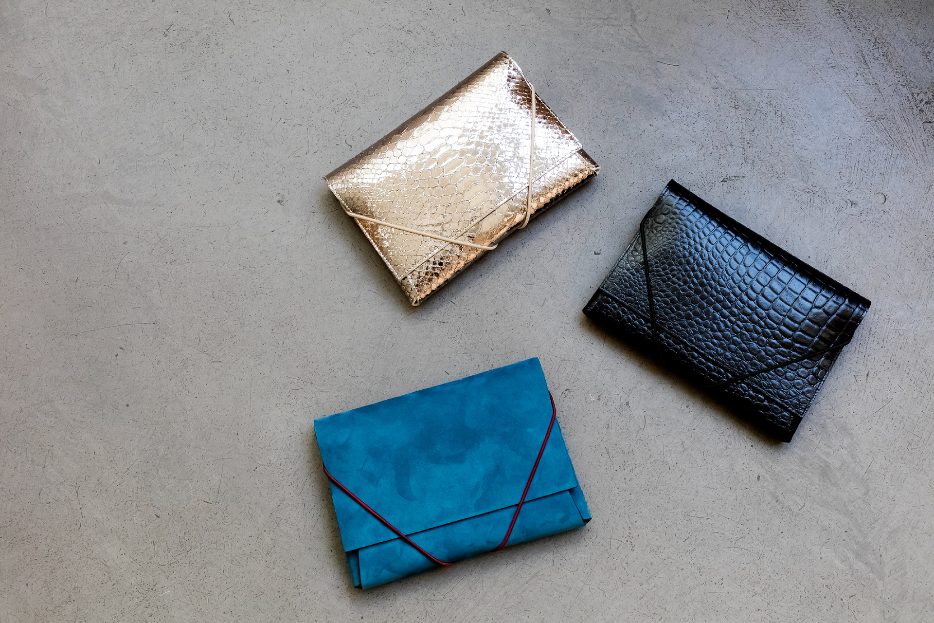 Pochettes IDEALE en cuir 15 x 22 cm - 180€ 1/ Cuir doré effet python 2/ Cuir noir effet crocodile 3/ Cuir daim bleu