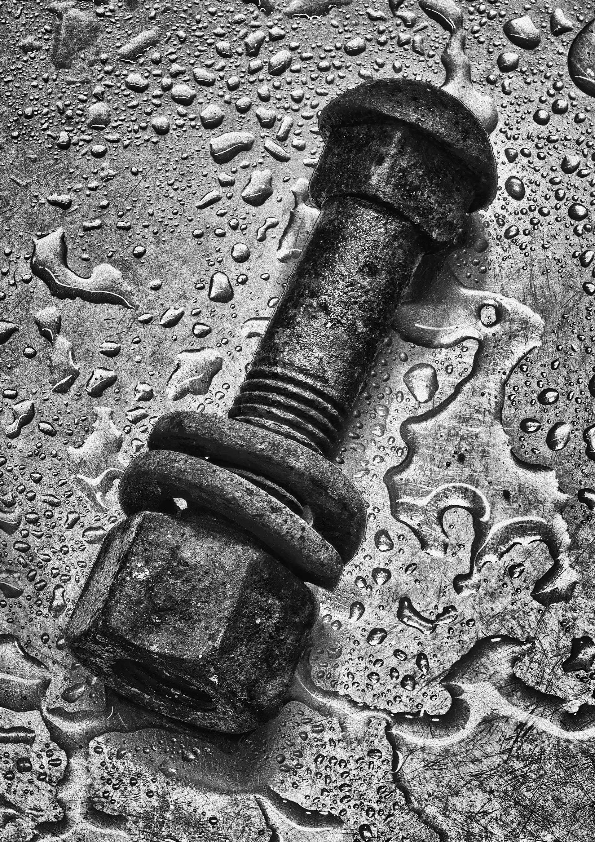 Large old rusty nut and bolt on a shiny metal surface with water drops