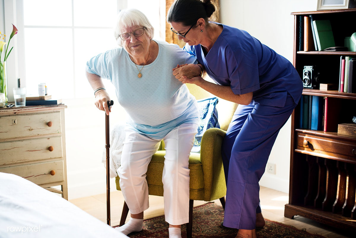 Elderly woman struggles to get up from chair