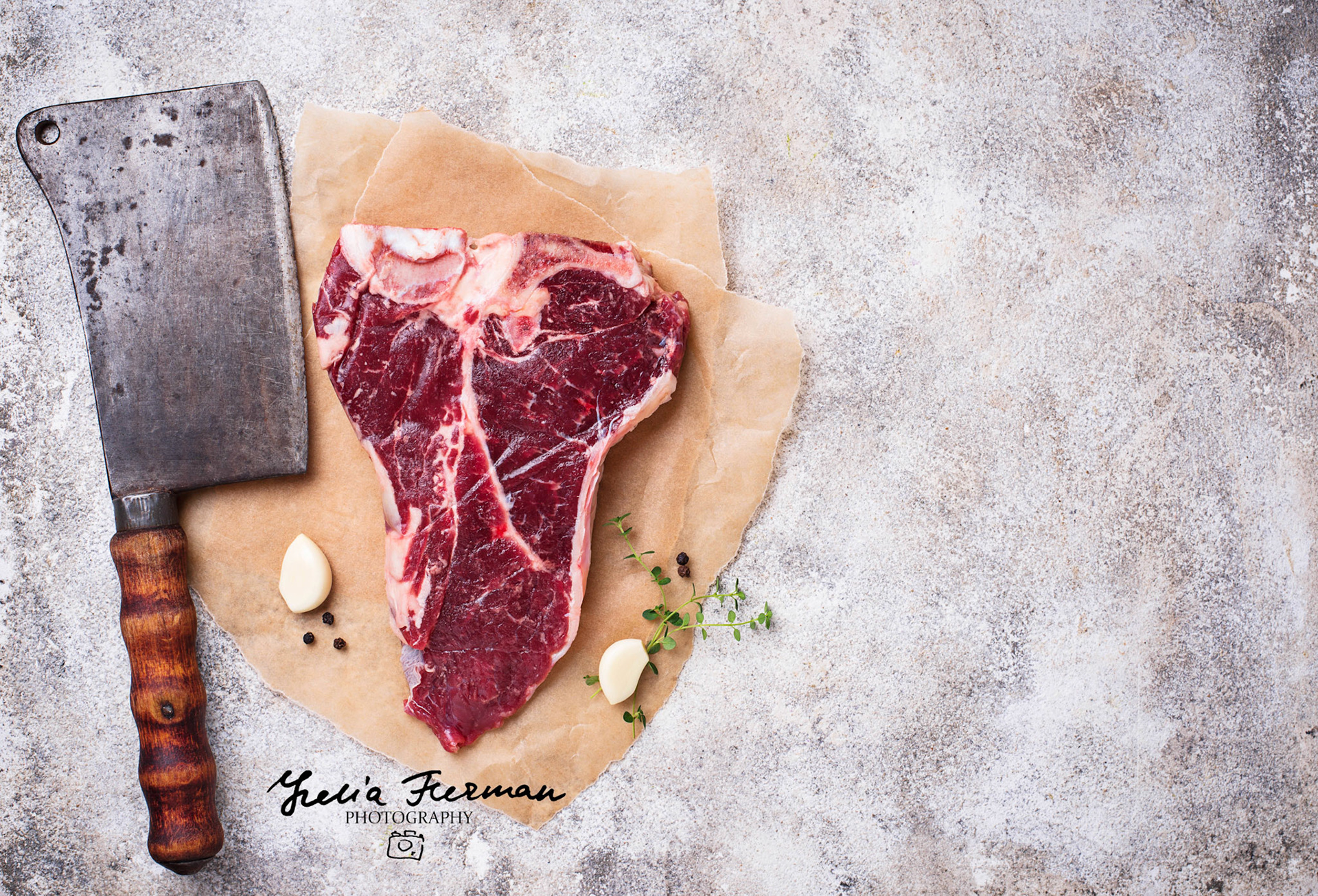 Raw T-bone steak with butcher's knife. Top view