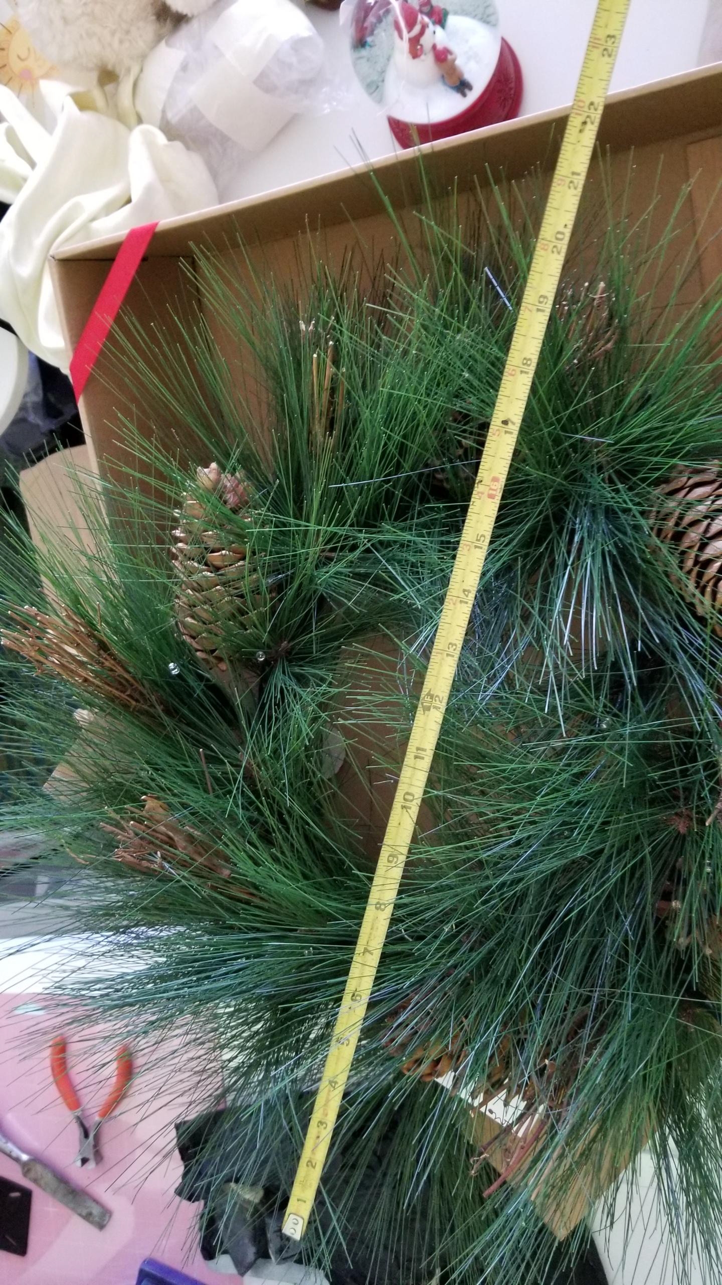 Measuring the wreath to make sure it fits perfectly above the mantle.