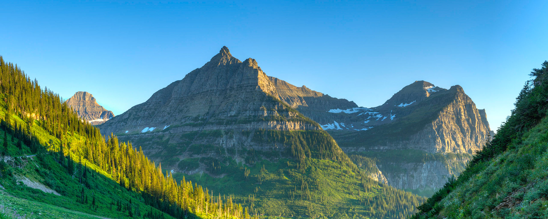Late afternoon sun on Mt. Oberlin and Mt. Cannon.  Bird Woman Falls, while visible, isn't prominent from this angle.Glacier National ParkJuly 31, 2015This is an HDR panoramic image consisting of 8 frames comprised of 5 exposures each. HDR processing performed in Photomatix Pro.  Panoramic stitching performed in Photoshop. Additional processing performed in Lightroom and Photoshop.PENTAX K-3, Sigma 18-35mm f/1.8 DC HSM ArtISO 100 32 mm  ⅙ sec at ƒ / 11
