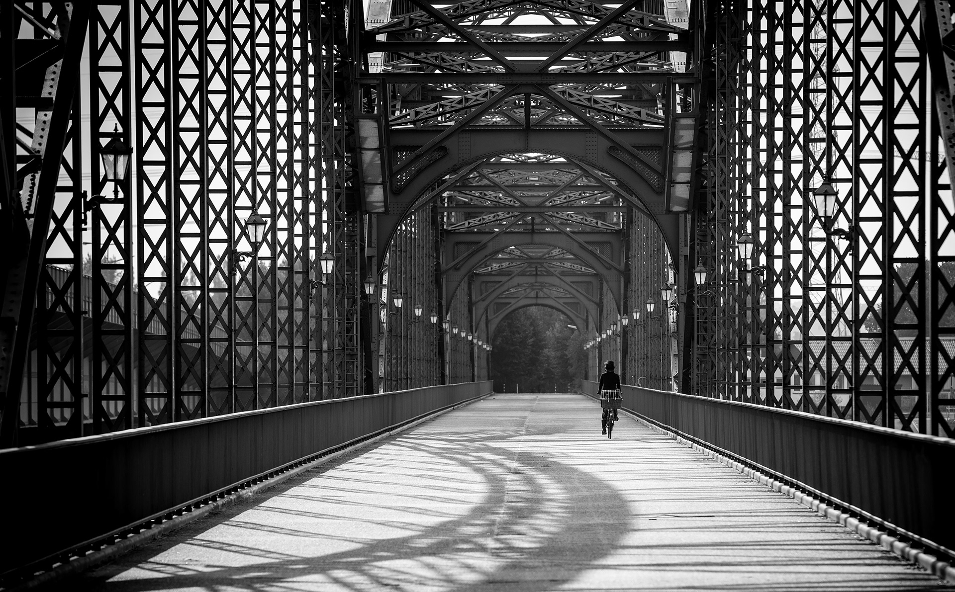 Alte genietete Stahlbrücke in schwarzweiss mit Radfahrerin, fotobagaluten, Hamburg