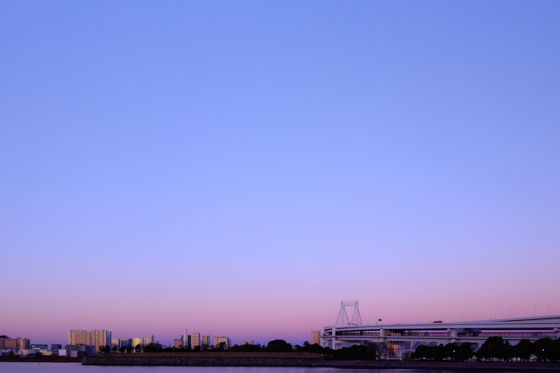 Cityscape of Tokyo at dawn. Illumination gives color to the monochromatic dark night and the world regain its color as the sun rises. This image was taken in December 2017, Tokyo, Japan.