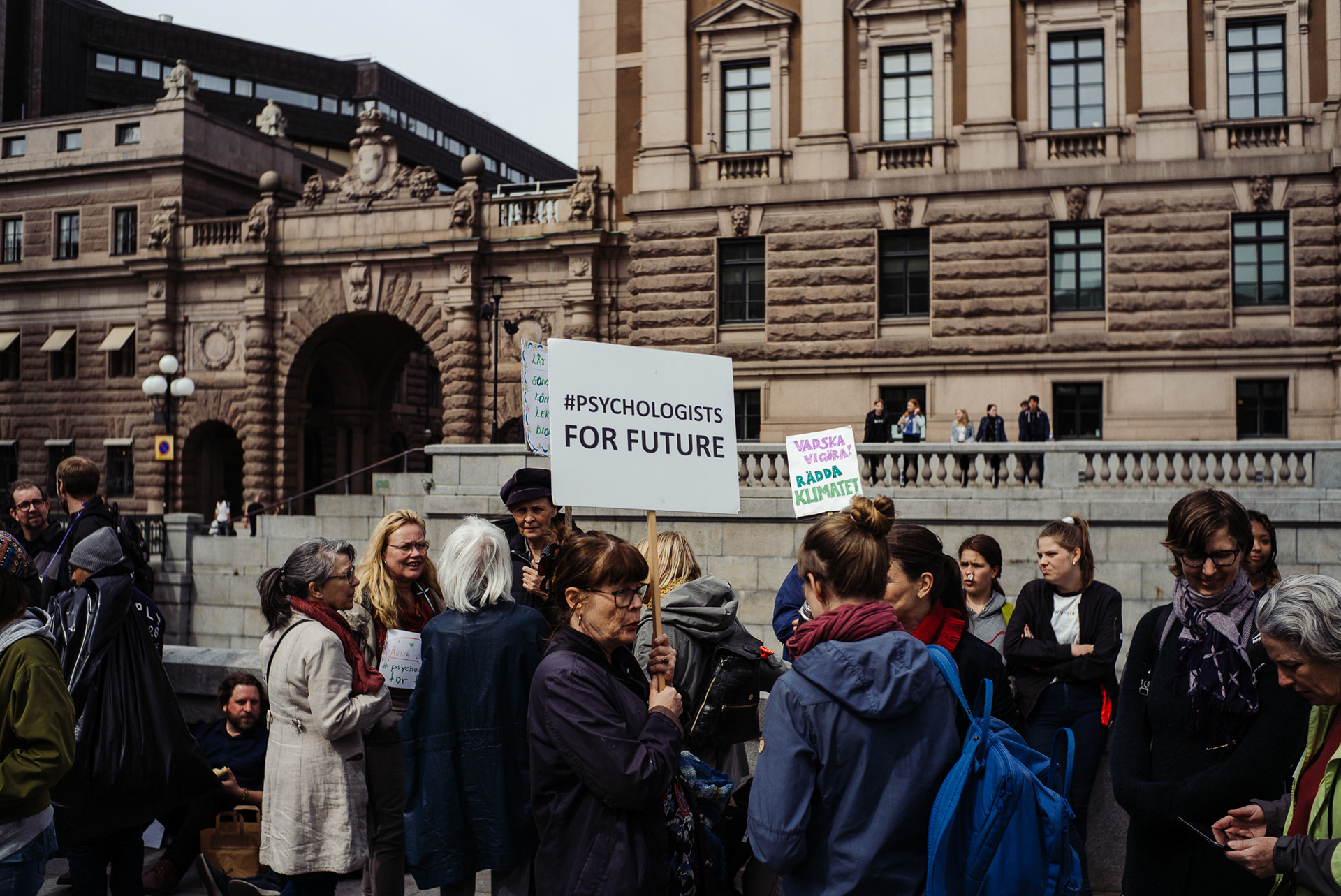 Adult strikers with sign in front of Riksdagshuset.