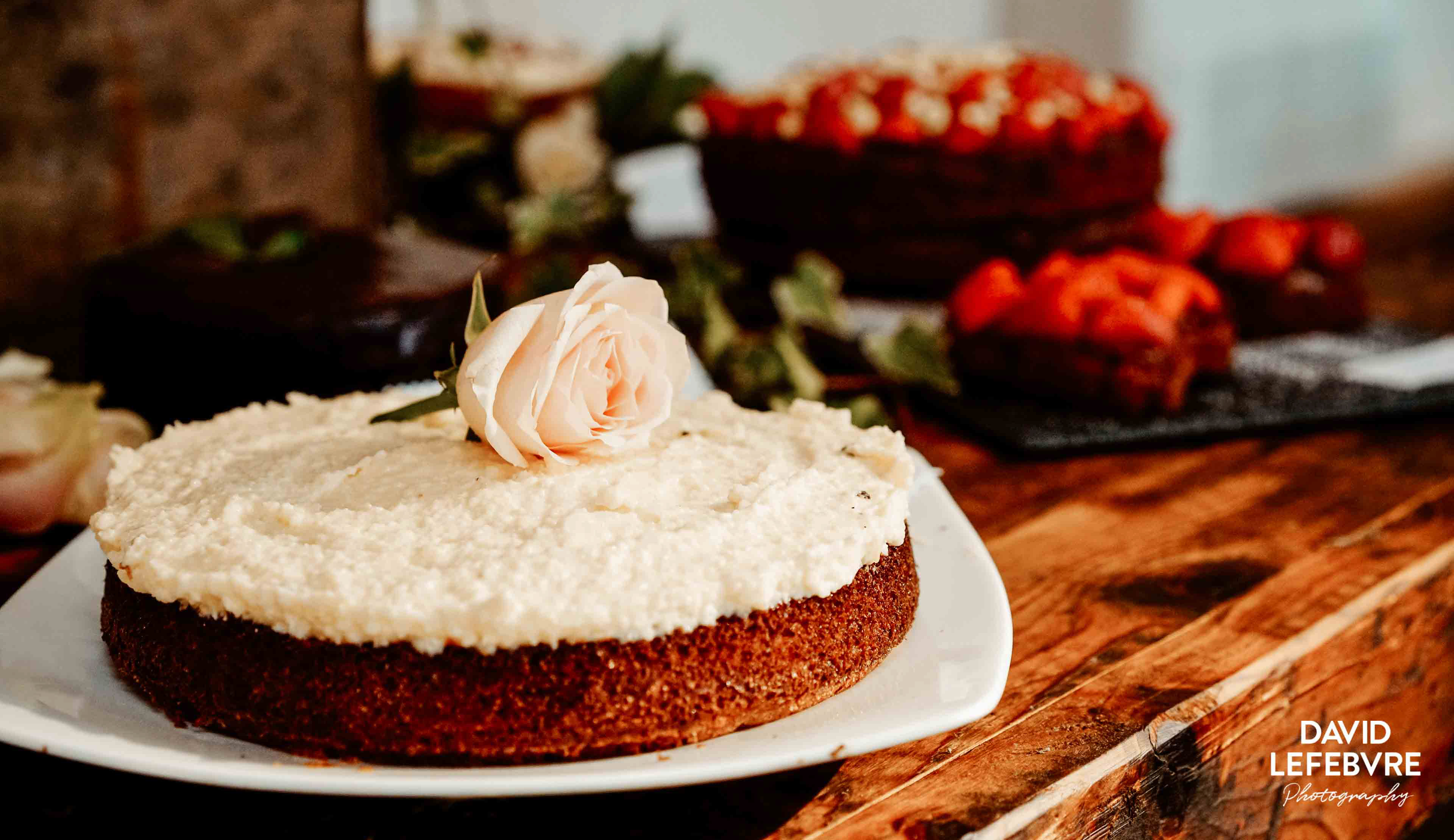 close up of sponge cake with white rose at owen barn house wedding
