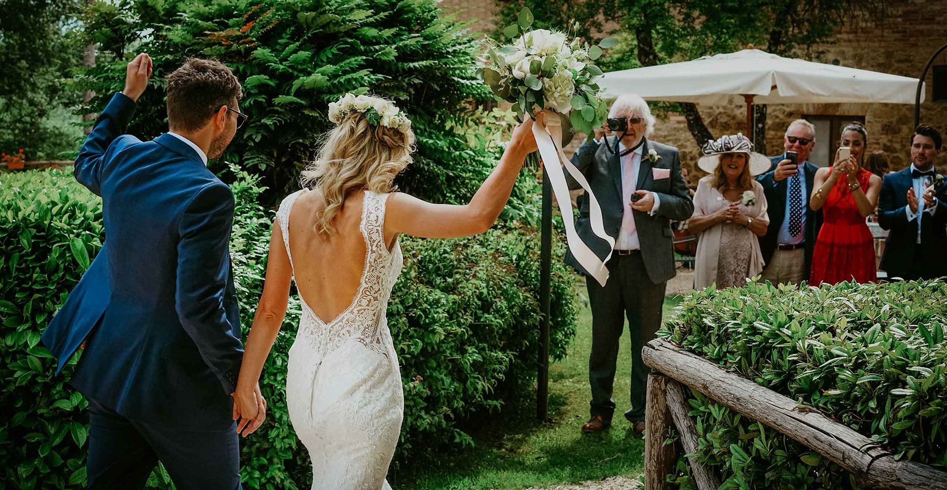 bride and groom happily meet close family and friends in hot summer wedding in italy at san galgano abbey with destination wedding photographer david lefebvre
