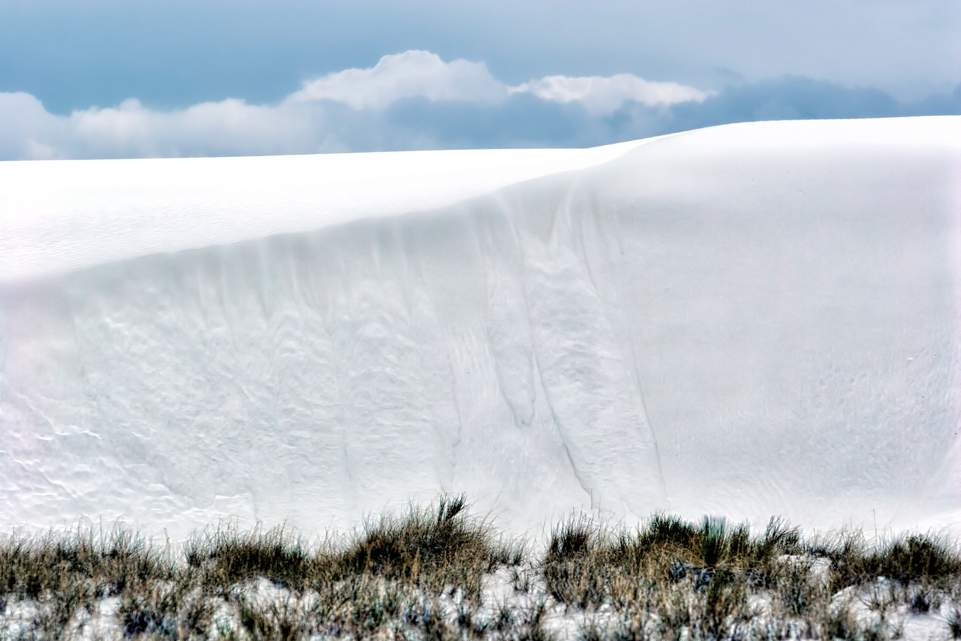 White Sands National Monument, New Mexico. Rising from the heart of the Tularosa Basin is one of the world's great natural wonders - the glistening white sands of New Mexico. Great wave-like dunes of gypsum sand have engulfed 275 square miles of desert, creating the world's largest gypsum dunefield. White Sands National Monument preserves a major portion of this unique dunefield, along with the plants and animals that live here.