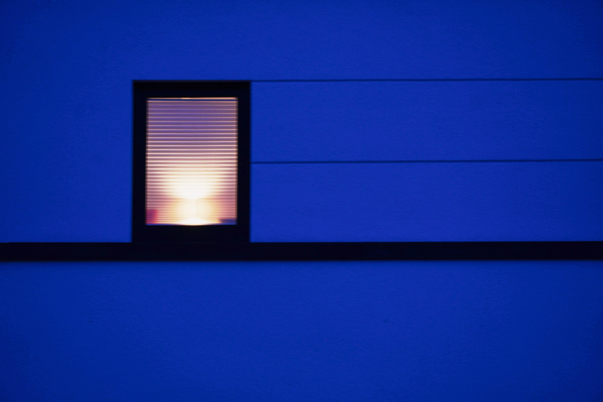 hausfassade zur blauen stunde mit fenster und licht