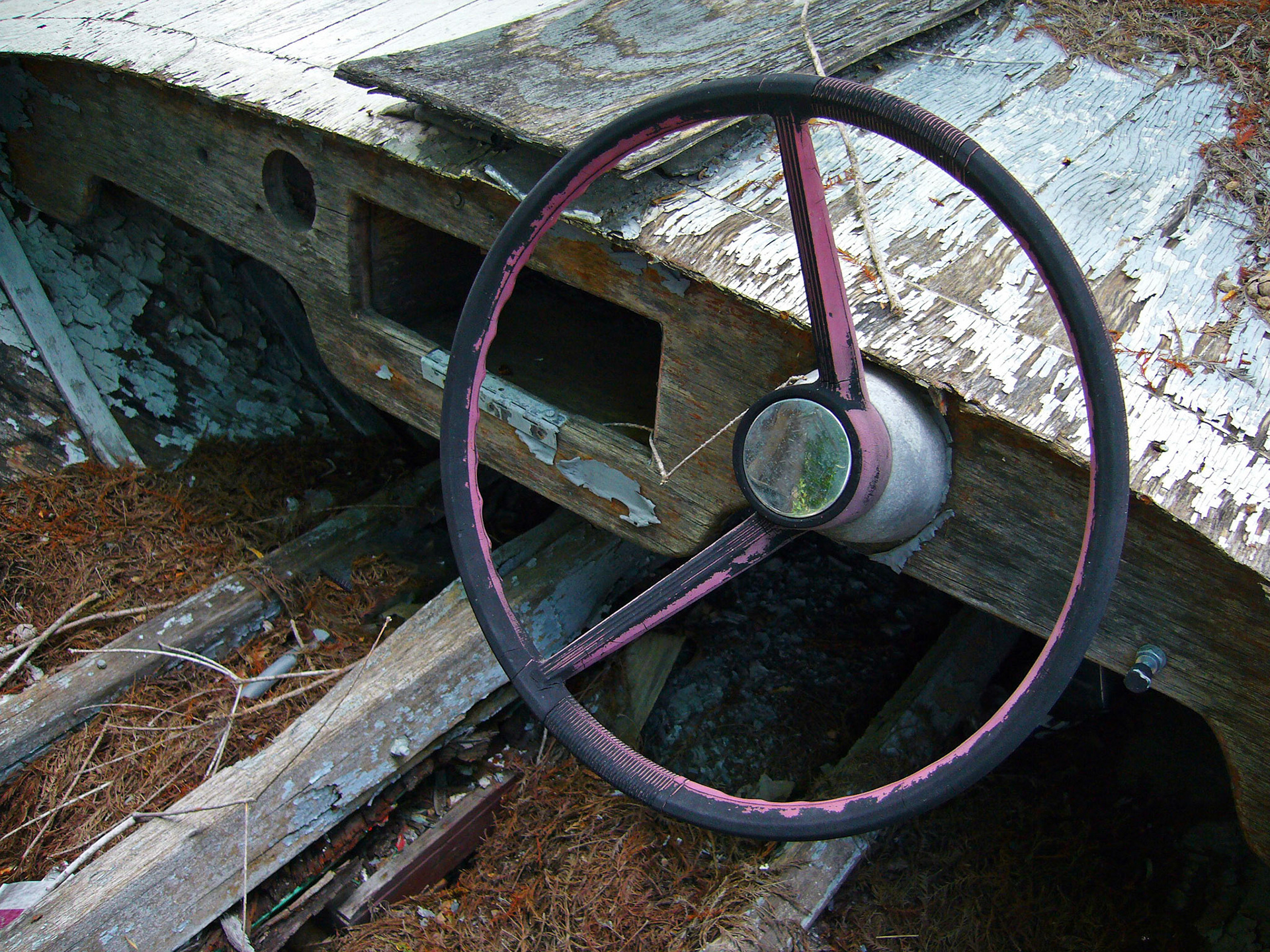 The steering wheel in a very old boat beached in Bastrop Texas.