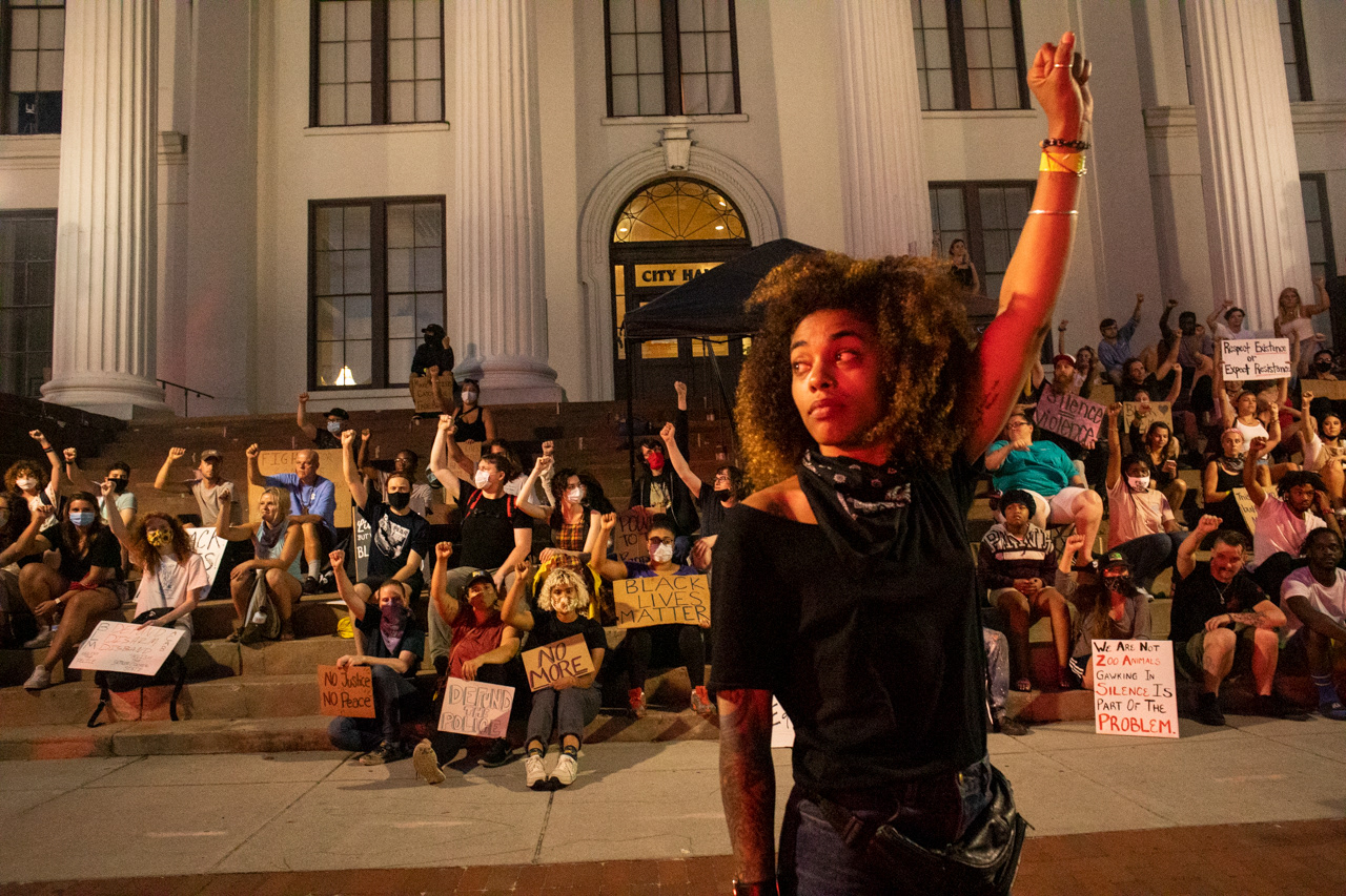 Lily Nicole, one of the event organizers, makes the black power gesture as an ambulance passes by to show respect for Wilmington's healthcare workers.