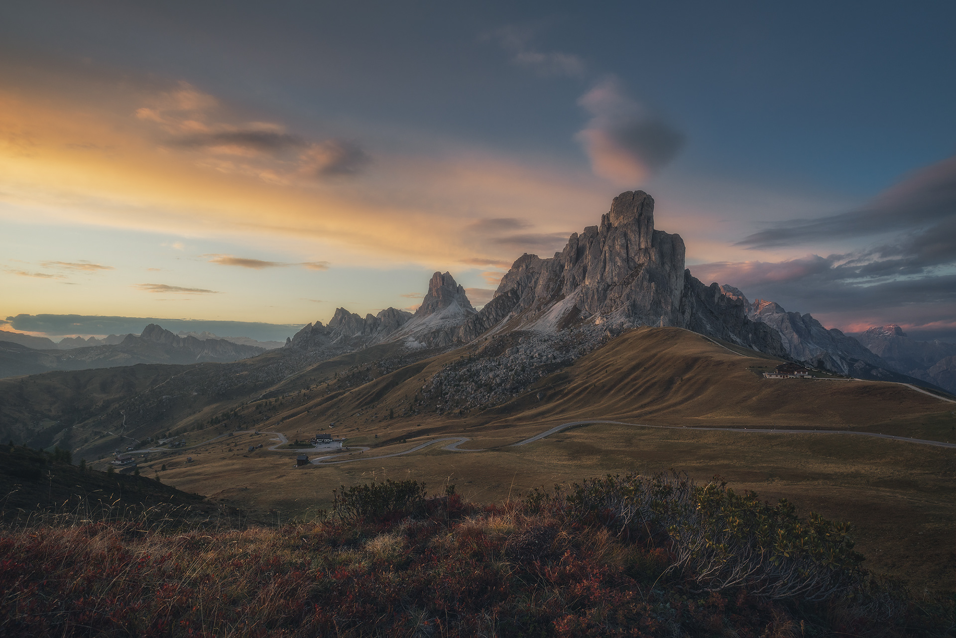 Montagne dans les Dolomites, à la fin de l'été. Coucher de soleil sur les premières couleurs d'automne. Nuage au dessus d'un pic, le tout ressemblant à un décor de cinéma.