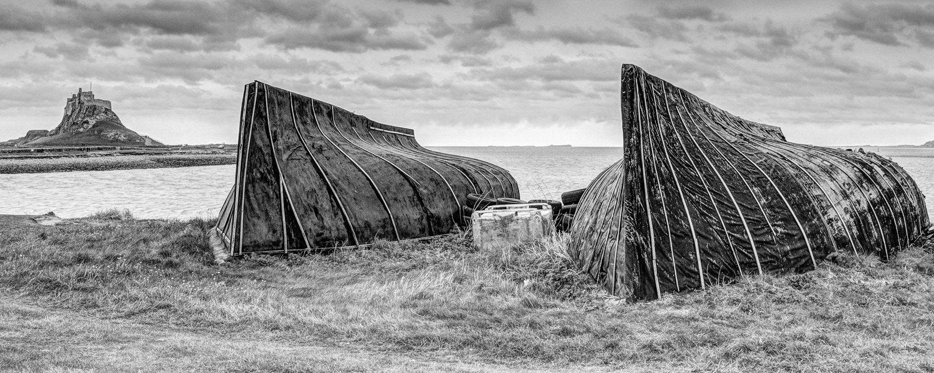 The boat sheds on the shore at Holy Island echo the shape of Lindisfarne Castle.A cold and windy outing to the Holy Island of Lindisfarne with Kirkcaldy Photographic Society, May 2012.In October 2013 this image was a winner in the Fife Art Exhibition at Kirkcaldy Galleries 2013 and earned a Shell Award from the sponsors Shell UK.