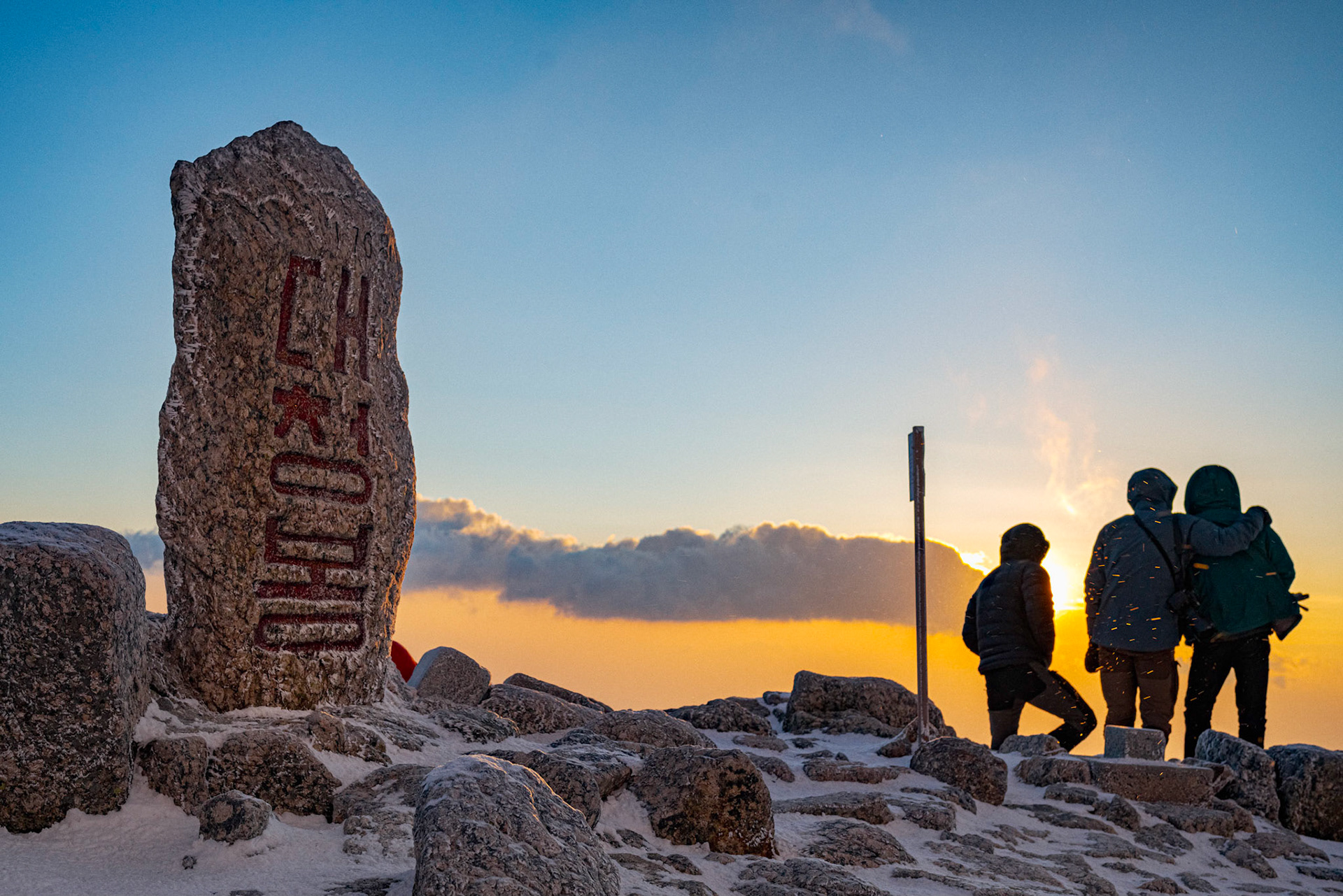 Seoraksan National Park, South Korea - FEB 03 2020: Hikers and Mountaineers congratulate eachother for braving gusts over 70kmph and windchill temperatures below -40 degrees C/F, and enjoy the reward of a beautiful sunrise. Hiking to the summit of high moutains to see the sunrise is a long standing tradition of Korean hikers and climbers. In winter, the challenge is much greater, but that does stop the most dedicated from pursuing their passion for hiking.