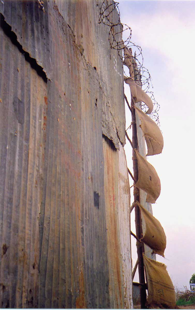 C.F.John, Size: 40ft x 20ft x 20f, Medium: corrugated metal sheets, marked water lines, water, sprouted seeds, barbed wire and gunny cloths.