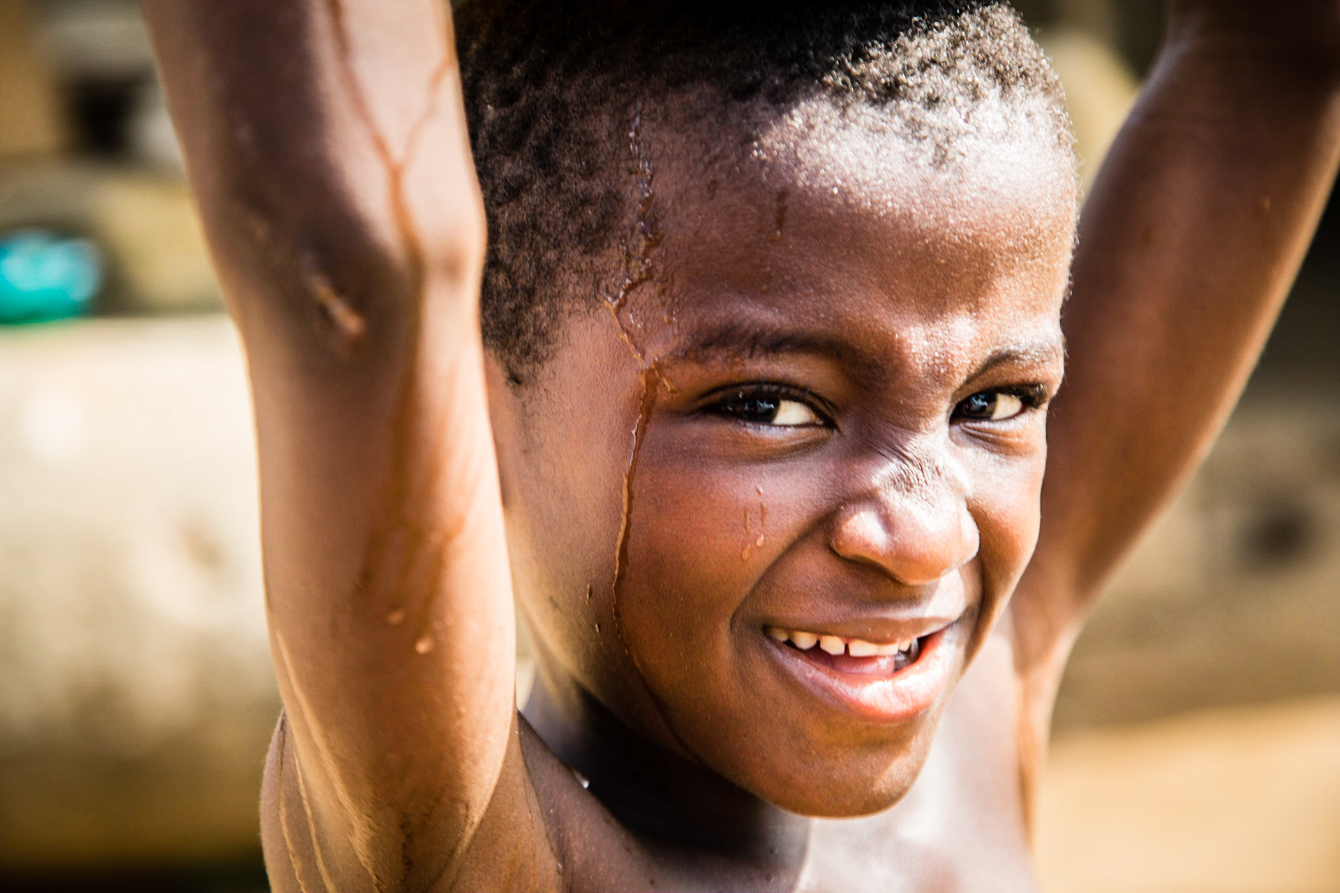 Liberia: Grand Cape Mount; 24 January 2015.  A boy carrys water in Grand Cape Mount.  Since the onset of the Ebola outbreak, Liberian Red Cross have been active in community engagement and social mobilization, in an effort to reduce transmission of the virus and stigma against survivors.  Photo: Stephen Ryan / IFRC