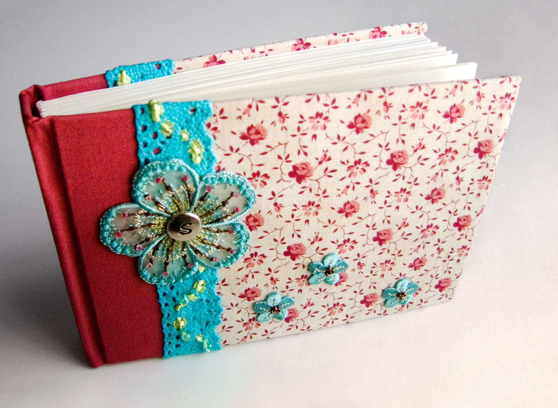 A case bound book with fabric covers and some craft store embellishment finds. A medium drawing paper was used for the pages.