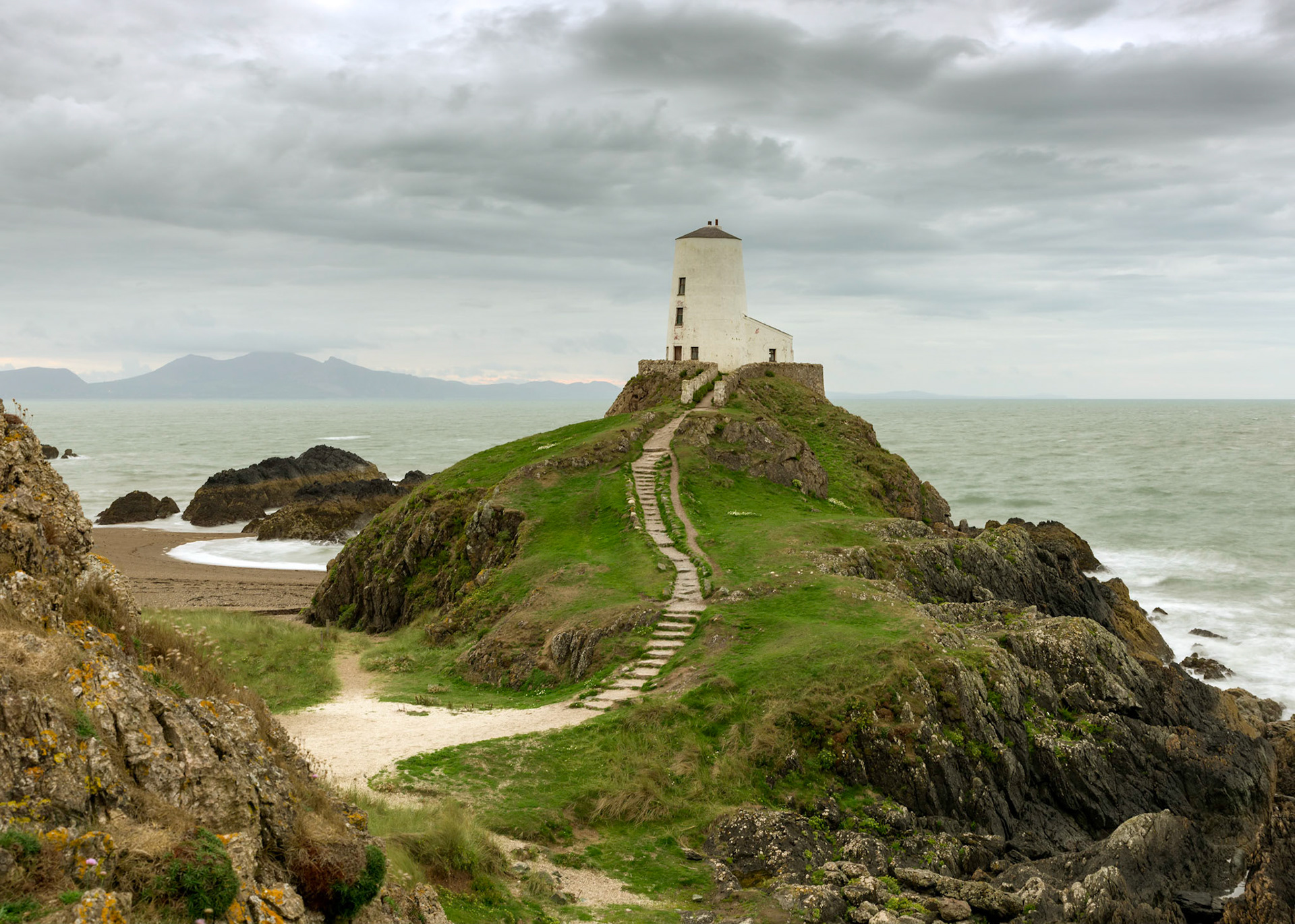 Ynys Llanddwyn or Llanddwyn Island is a small tidal island off the west coast of Anglesey (Welsh: Ynys Môn), northwest Wales.

Tŵr Mawr lighthouse (meaning "great tower" in Welsh), marks the western entrance to the Menai Strait.  The 1873 tower is tapered in a style characteristic of Anglesey windmills. It is 33 feet (10 m) high and 18 feet (5.5 m) in diameter. It may have been constructed by an Anglesey stone mason, and it is possible that the tower itself was originally used as a windmill.