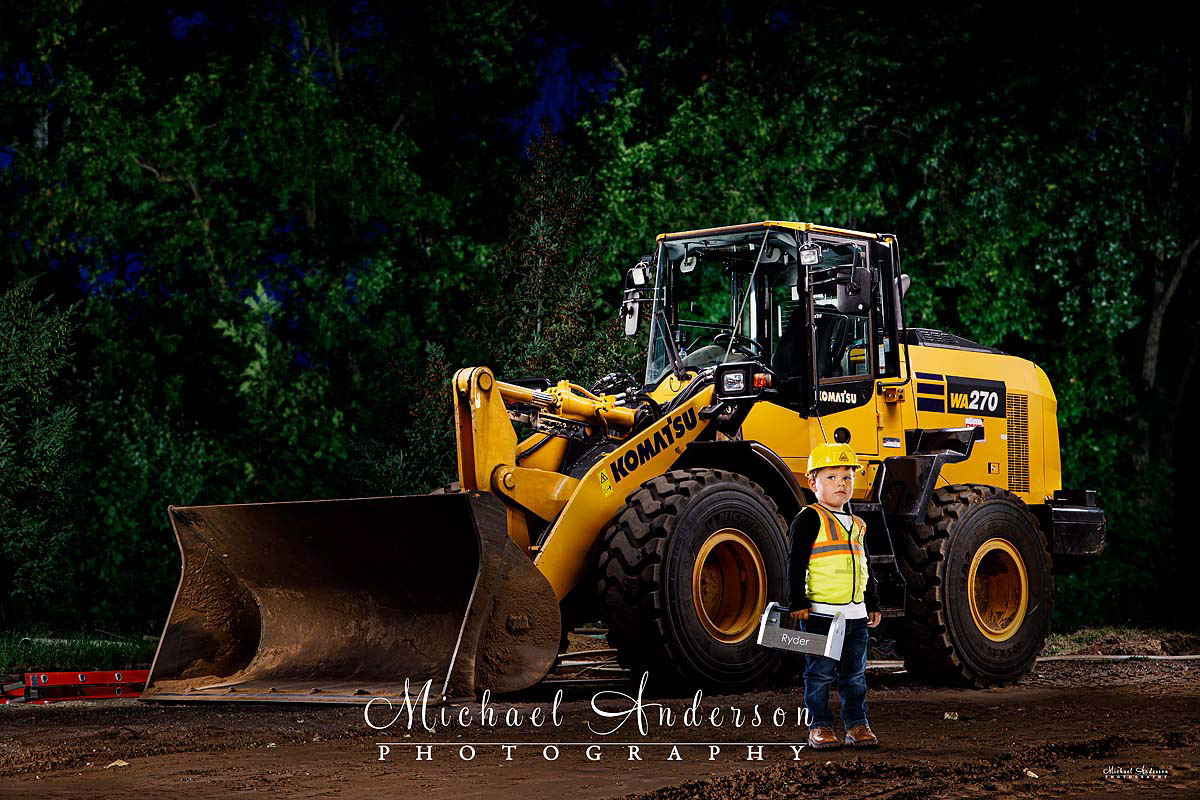 A cool light painting of a Komatsu WA270-8 front loader and a three-year-old boy in a construction outfit.