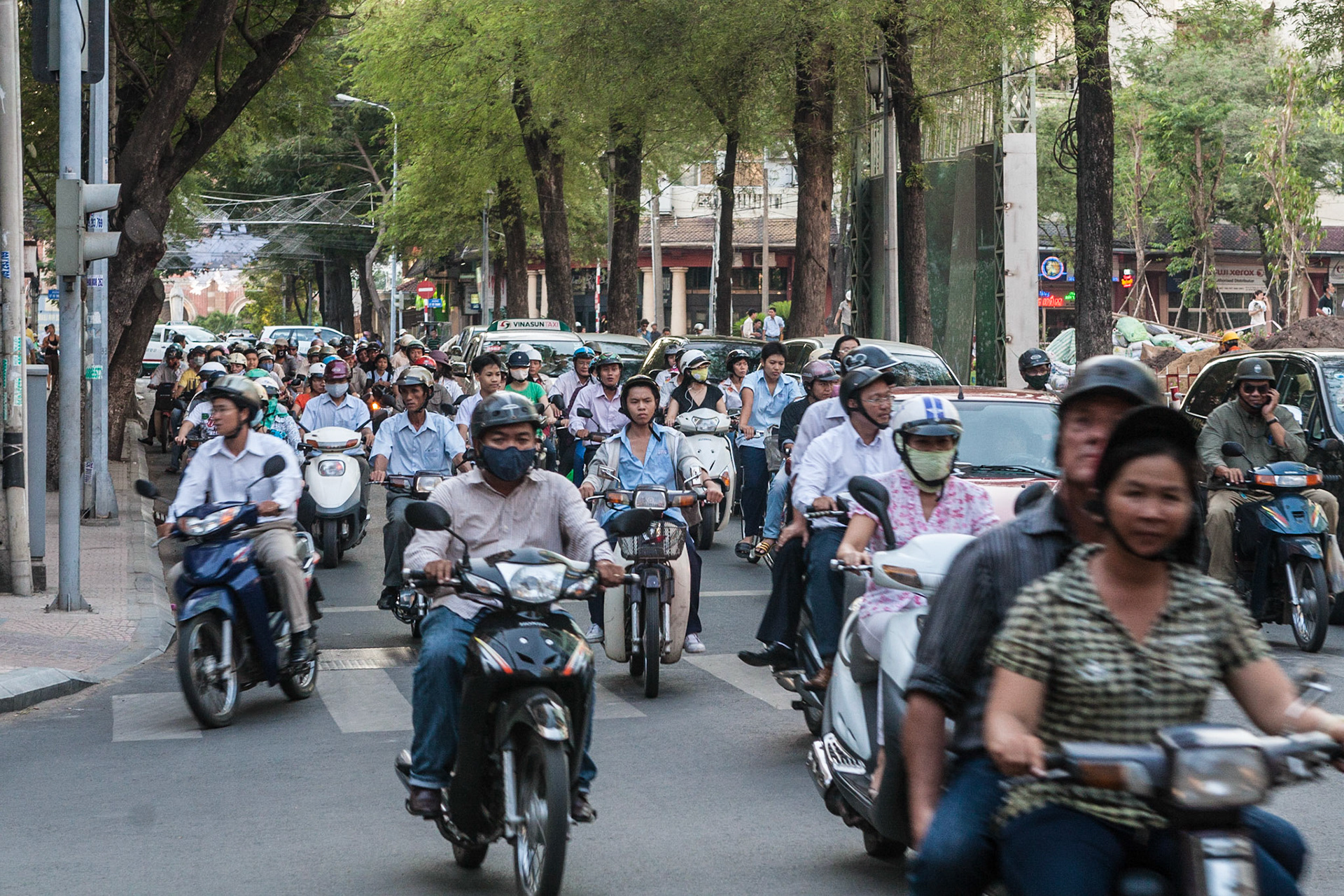A flock of motorcycle drivers passing by in a typical street scene in Saigon/ Ho Chi Minh City, Vietnam