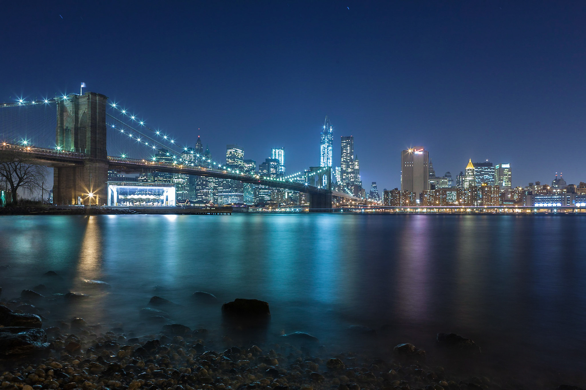 A misty view from Dumbo over the Brooklyn Bridge towards Downtown Manhattan at night