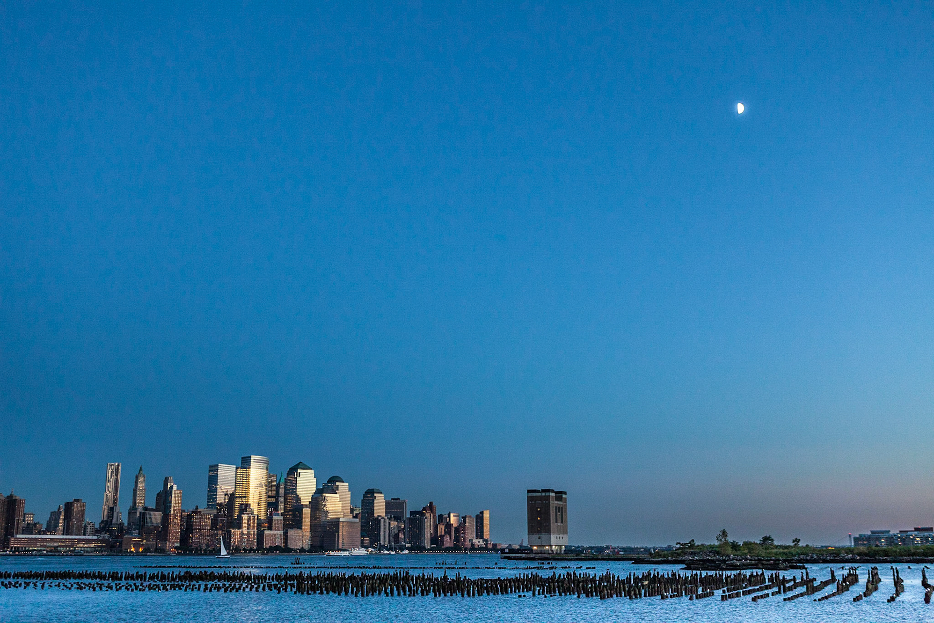 An image of Lower Manhattan and the Financial District in the distance, taken from the waterfront walkway between Hoboken and Pavonia-Newport on the New Jersey side.