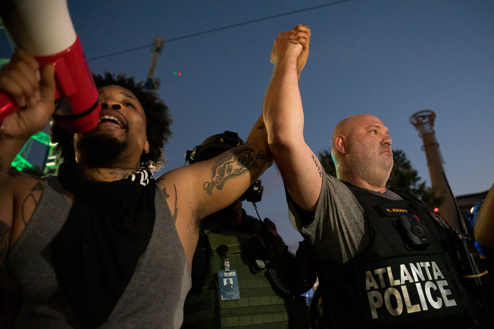 Farees Kaleemah, 27, and Atlanta Police Officer identified as K. Knapp, hold hands and try to deescalate the third day of protests in downtown Atlanta on May 31.