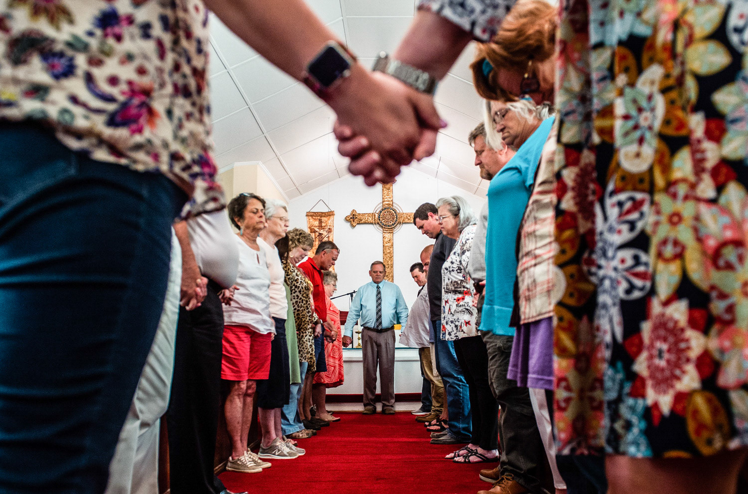 Members of the congregation at Elkmont United Methodist Church hold hands at the conclusion of a prayer vigil on September 3 in Elkmont after a 14-year-old boy admitted to killing five members of his family in Elkmont, including his three younger siblings.