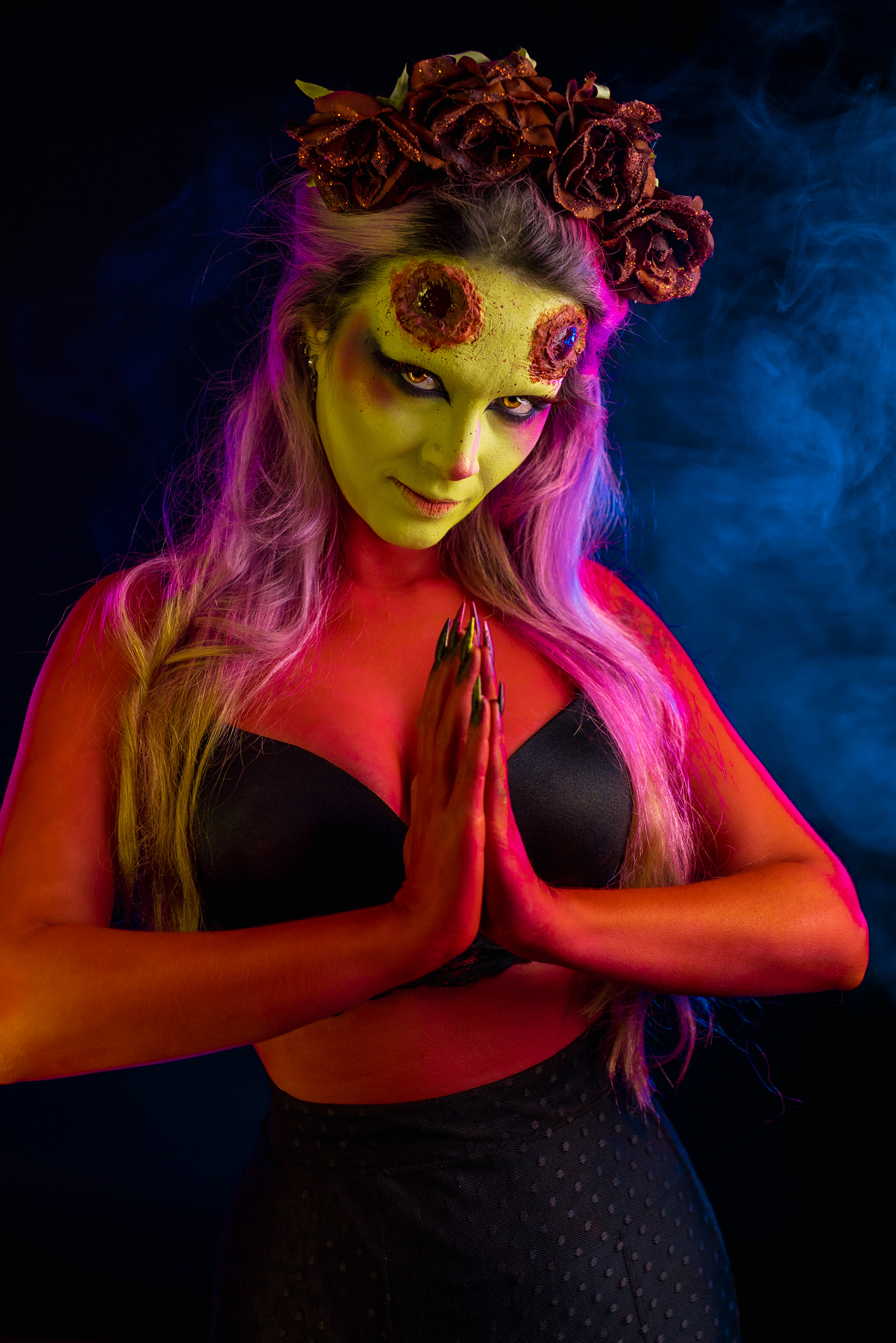 demon woman artistic makeup red skin yellow eyes on black background