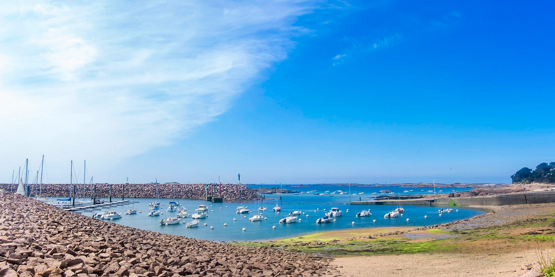 Lovely tiny white boats on the blue waters of the English channel in Trébeurden, Bretagne.